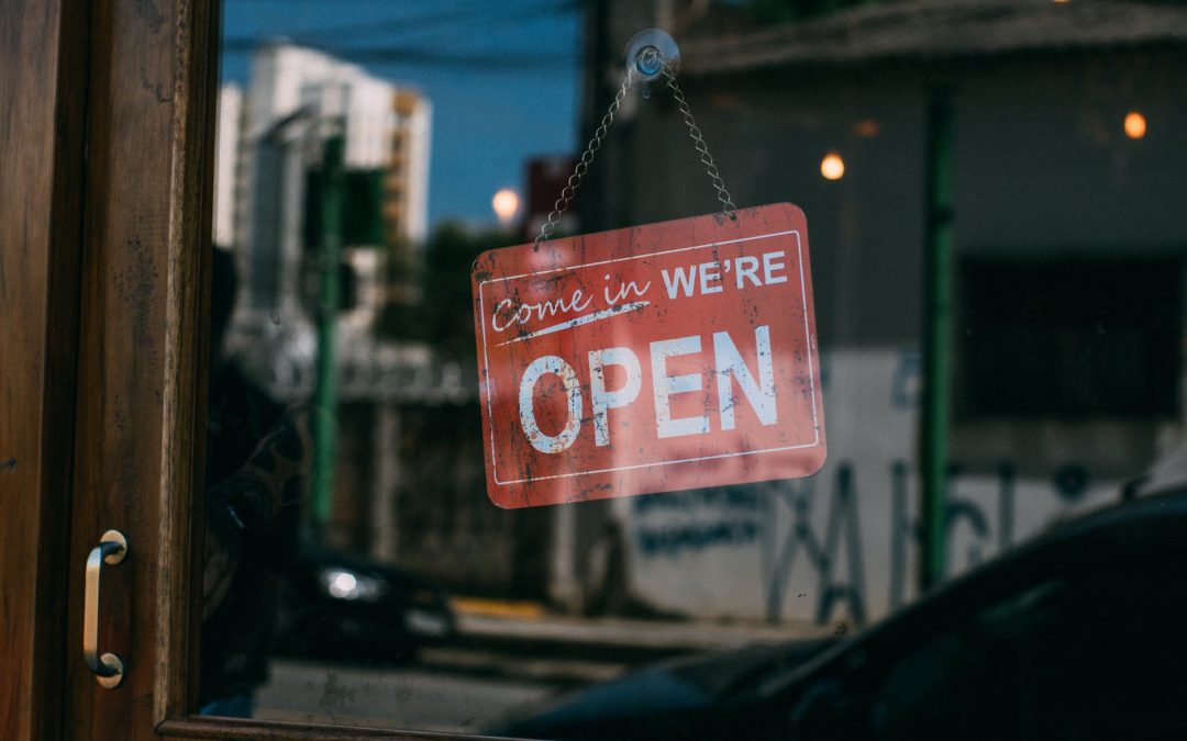 open signage hanging on glass door of vicinity